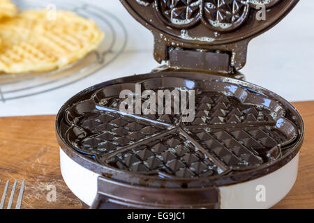 Hausgemachte Waffeln werden in einem Waffeleisen zubereitet. Stockfoto