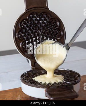 Hausgemachte Waffeln werden in einem Waffeleisen zubereitet. Stockfoto