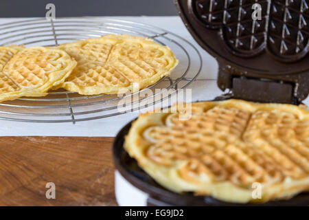 Hausgemachte Waffeln werden in einem Waffeleisen zubereitet. Stockfoto