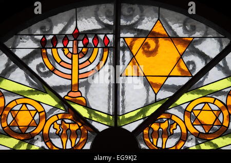 Magen Davidstern und Menora gemalt auf einem ein Buntglasfenster Stockfoto