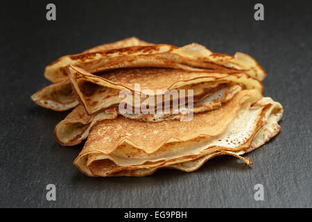 dünne Crepes oder Blinis gefaltet in Dreiecke auf Schiefer Stockfoto