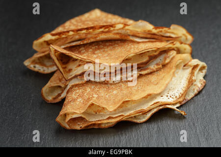 dünne Crepes oder Blinis gefaltet in Dreiecke auf Schiefer Stockfoto