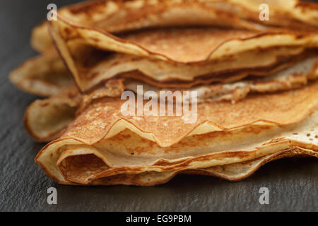 dünne Crepes oder Blinis gefaltet in Dreiecke auf Schiefer Stockfoto