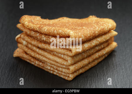 dünne Crepes oder Blinis gefaltet in Dreiecke auf Schiefer Stockfoto