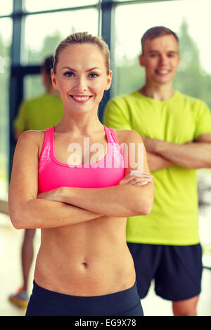 lächelnder Mann und Frau im Fitness-Studio Stockfoto