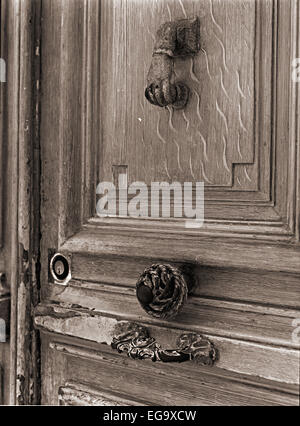 Schwarzweiß-Aufnahme einer alten Tür und Hand geformt Türgriff. Stockfoto
