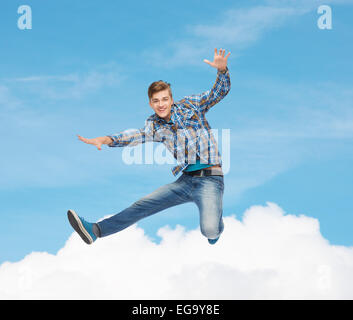 lächelnder junge Mann springt in die Luft Stockfoto