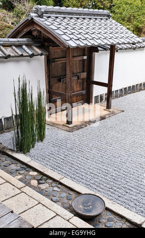Kyoto, Japan. Shoden-Ji Zen-buddhistischen Tempel. Eine dekorative Schale im trockenen Kies (Kare-Sansui) Garten neben dem formalen Tor Stockfoto