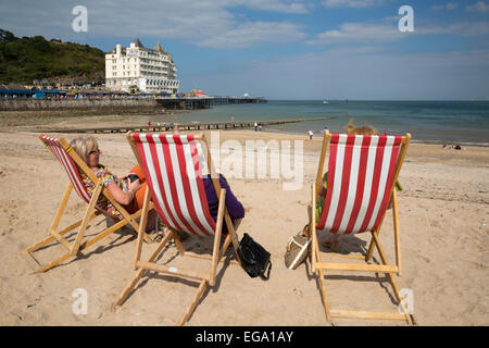 Liegestühle am Strand mit dem Grand Hotel, Llandudno, Conwy, Wales, Vereinigtes Königreich, Europa Stockfoto