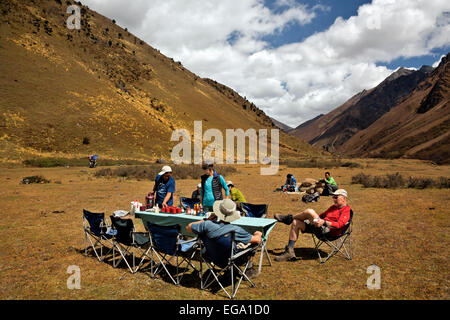 BU00178-00... BHUTAN - Trekker Mittagessen in einer offenen Wiese oberhalb der Waldgrenze im Paro Tal in der Nähe des Dorfes Dangochang. Stockfoto