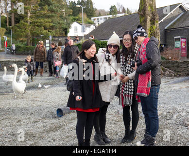 Touristen, die mit mobilen Smartphone Iphone Selfie - Selfies kleben zu fotografieren & Video von sich Lake Windermere Cumbria 20. Februar 2015. Bowness Bay. Kalten Semesterhälfte für Bootsfahrten & Touristen von allen Nationalties Credit: Gordon Shoosmith/Alamy Live News Stockfoto