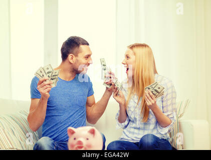 paar mit Geld und Sparschwein ot Tisch daheim Stockfoto