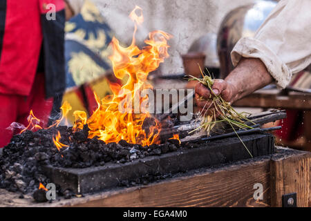 Schmied Abkühlung Metall mittels nassen grünen Zweige Stockfoto