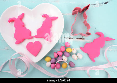 Happy Easter rosa Süßwaren Zucker Fondant Cookie Hasen auf weißes Herz Form Platten auf blass Aqua blau shabby chic Vintage s Stockfoto