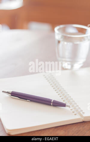 Stift und leere Spiral-Notizbuch auf Holztisch, Fotoarchiv Stockfoto