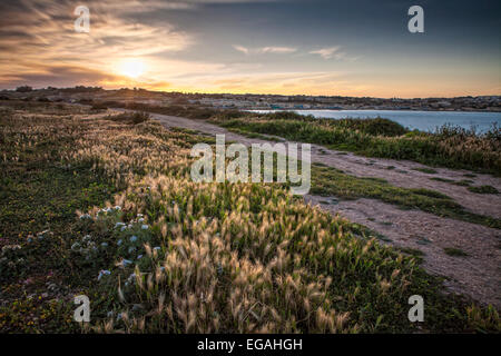 Einen schönen Frühling Sonnenuntergang über der idyllischen Umgebung des St. Thomas Bay in Malta. Stockfoto