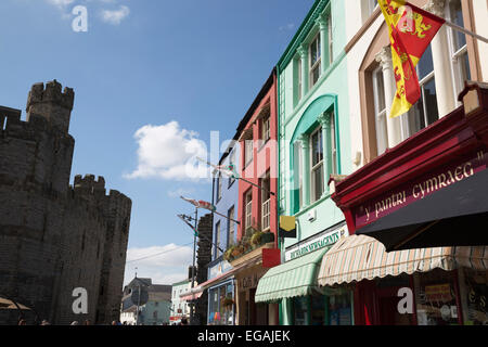 Ladenfronten unter Caernarfon Castle, Schlossplatz, Caernarfon, Snowdonia, Gwynedd, Wales, Vereinigtes Königreich, Europa Stockfoto