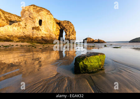 Perranporth Strand bei Sonnenaufgang an einem klaren Morgen zeigen, einen großen Bogen in der Landzunge, die den Sand im Wasser reflektieren. Stockfoto