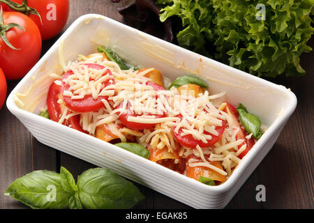 Cannelloni darauf vorbereiten, in einem Bräter auf einem hölzernen Hintergrund Backen Stockfoto