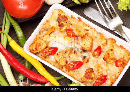 Auflauf mit Huhn und Paprika auf einem hölzernen Hintergrund Stockfoto