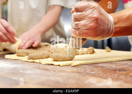 Baker fügt tortencreme für croissants Stockfoto