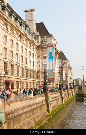 Touristen, die zu Fuß auf die Albert Embankment und County Hall im Sommer, London, England Stockfoto