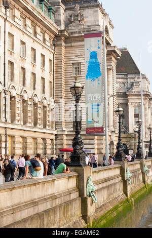 Touristen, die zu Fuß auf die Albert Embankment und County Hall im Sommer, London, England Stockfoto