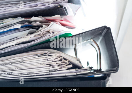 Rote, grüne, blaue und gelbe Office-Ordner mit Boxen auf dem grauen Regal Stockfoto