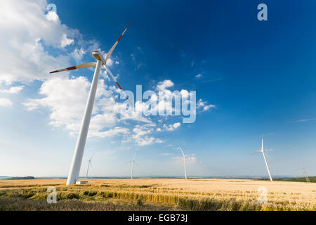 Eine enge Windkraftanlage in einem Windpark, der scheint zu schauen auf kleineren Windturbinen im Hintergrund. Gesehen in der Eifel, Germa Stockfoto