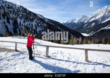 Fotografin nimmt Bilder in den Bergen von Staller Sattel aus Italien nach Österreich Stockfoto