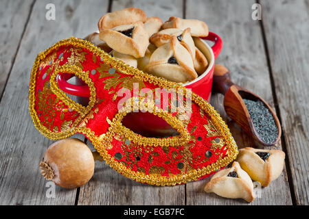 Hamantaschen Cookies oder Hamans Ohren und Karnevalsmasken für Purim Feier (jüdischer Feiertag). Stockfoto