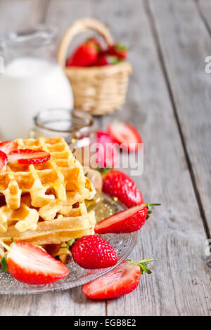 Hausgemachte Waffeln mit Reife Erdbeere, Honig und Milch auf hölzernen Hintergrund Stockfoto