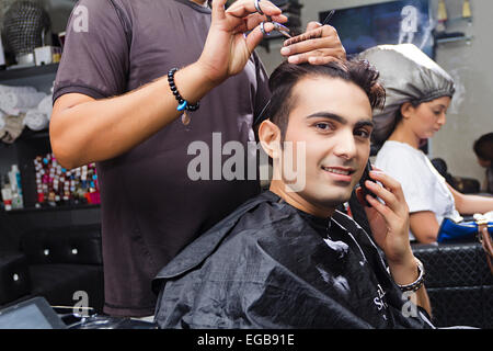 2 indische Menschen Friseur schneiden Salon sprechen Telefon Stockfoto