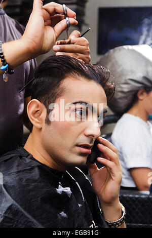 2 indische Menschen Friseur schneiden Salon sprechen Telefon Stockfoto