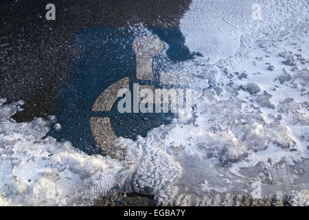 Handicap nur Symbol auf verschneiten Parkplatz parken. Stockfoto