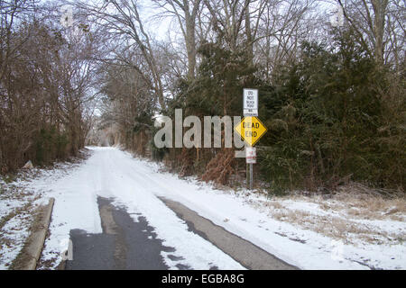 Verschneiten bewaldeten Fahrbahn mit Sackgasse melden Sie vorne am Eingang. Stockfoto