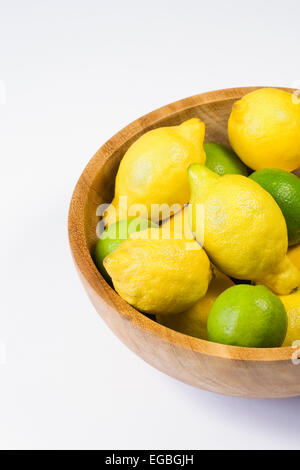 Zitronen und Limetten in einer Holzschale. Stockfoto
