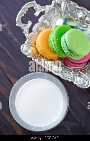 Milch im Glas und Farbe Makronen Stockfoto