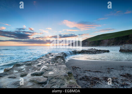 Wellen brechen über ein altes Kopfsteinpflaster Hafen Wand Portwrinkle an der südöstlichen Küste von Cornwall Stockfoto