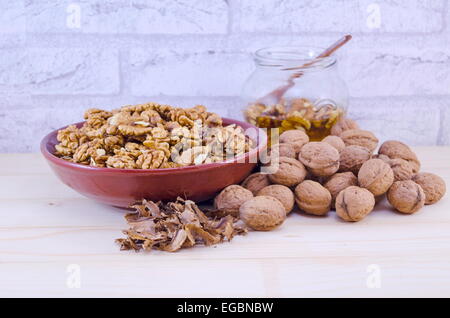 Ganze und gebrochene Walnüsse auf einem Tisch Stockfoto