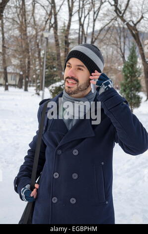 Mann auf einem Smartphone im winter Stockfoto