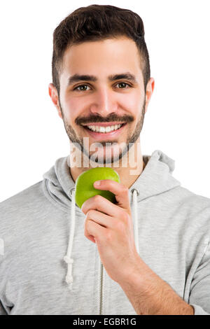 Gut aussehende Latein-Mann isst einen grünen Apfel, isoliert auf weißem Hintergrund Stockfoto