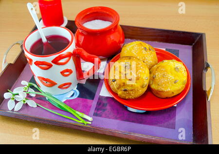 Lippe gemusterten Tee Becher und Maisbrot auf einem Tablett Stockfoto