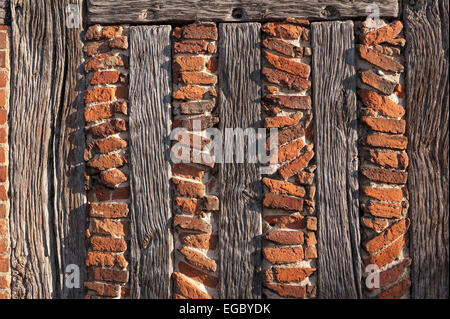 geistreichen Sonnenlicht zeigt die feineren Details der handgefertigten roten Lehmziegeln und Holzstütze Eiche Holz Balken Tudor Stockfoto