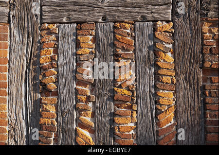 geistreichen Sonnenlicht zeigt die feineren Details der handgefertigten roten Lehmziegeln und Holzstütze Eiche Holz Balken Tudor Stockfoto