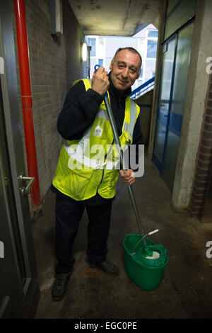 Wischen den Boden von einem Lift oder Aufzug in einem Wohnblock London Mann Stockfoto