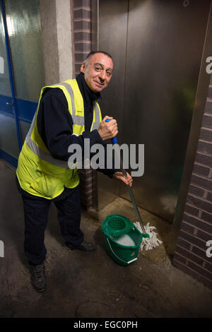 Wischen den Boden von einem Lift oder Aufzug in einem Wohnblock London Mann Stockfoto