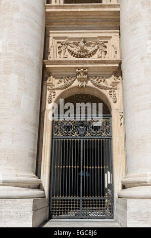 Steinmetzarbeiten über eine dekorative Metall Tor an der Basilika St. Peter, Vatikan, Rom, Italien. Stockfoto