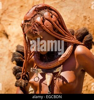 Eine junge Frau, die zu den einheimischen Himba abgebildeten Personen in ihrem Dorf im Kaokoveld, Namibia, Afrika. Stockfoto