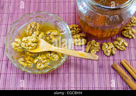 Walnüsse, Honig und Zimt in einem Glas auf einem Holztisch Stockfoto